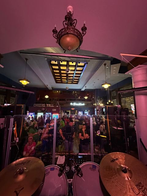 The view out from behind the drum kit toward a full room