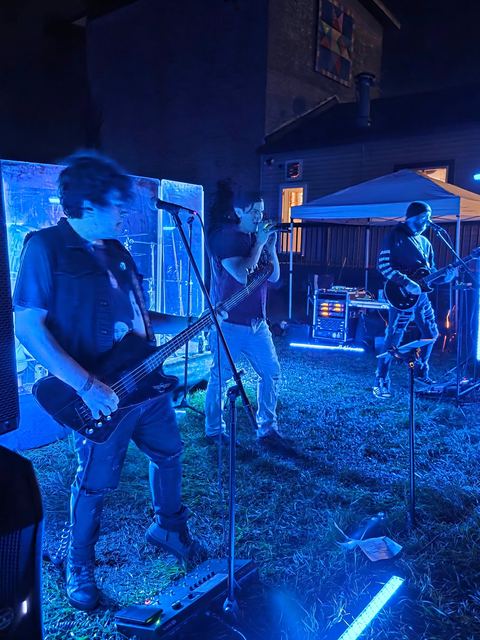 Two of the band playing side by side under blue light