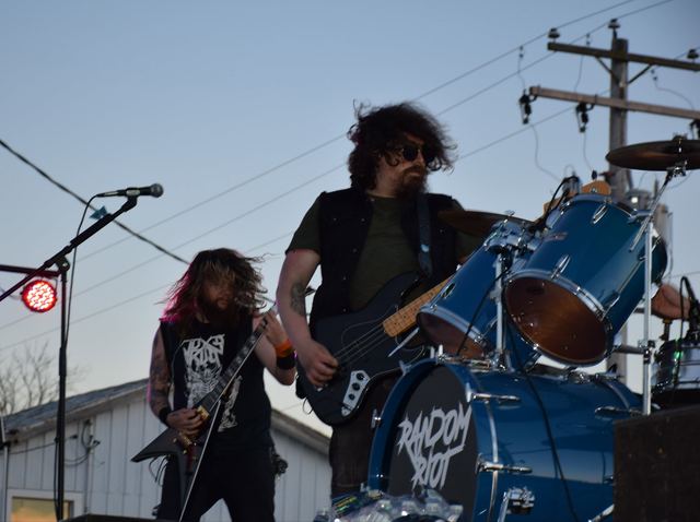 Bassist and guitarist playing an outdoor show against a blue sky