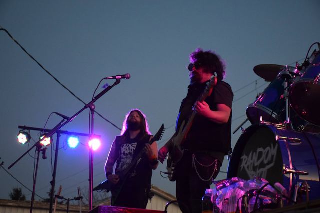 The band playing outdoors at dusk as the stage lights come up